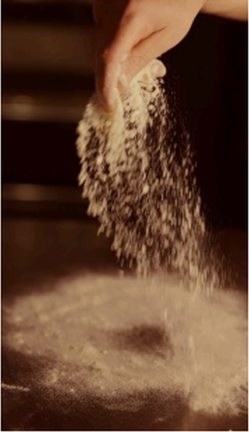 Showcase video frame: flour falling in slow motion